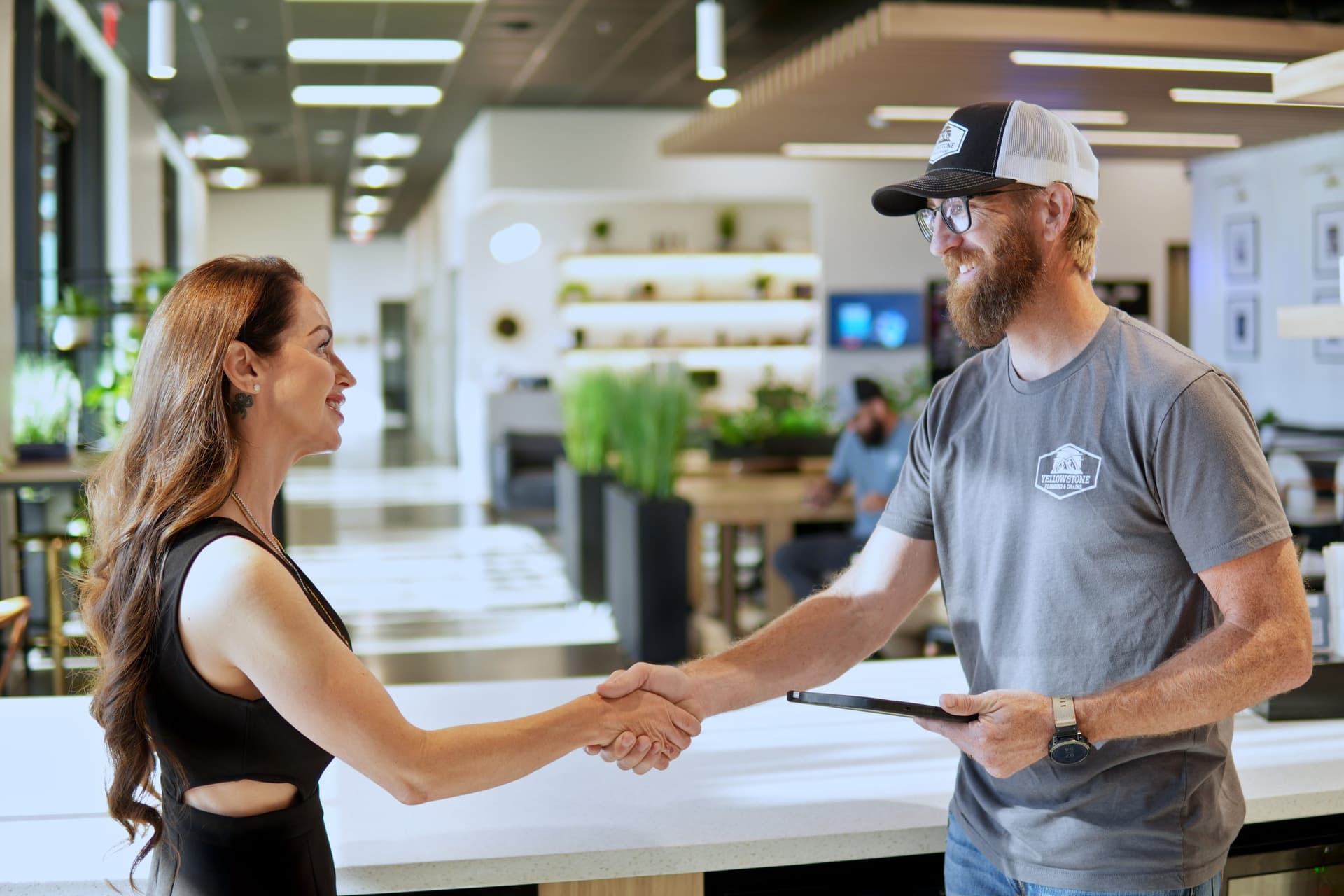 Josh Chasteen of Yellowstone Plumbing shaking hands with a customer in a showroom