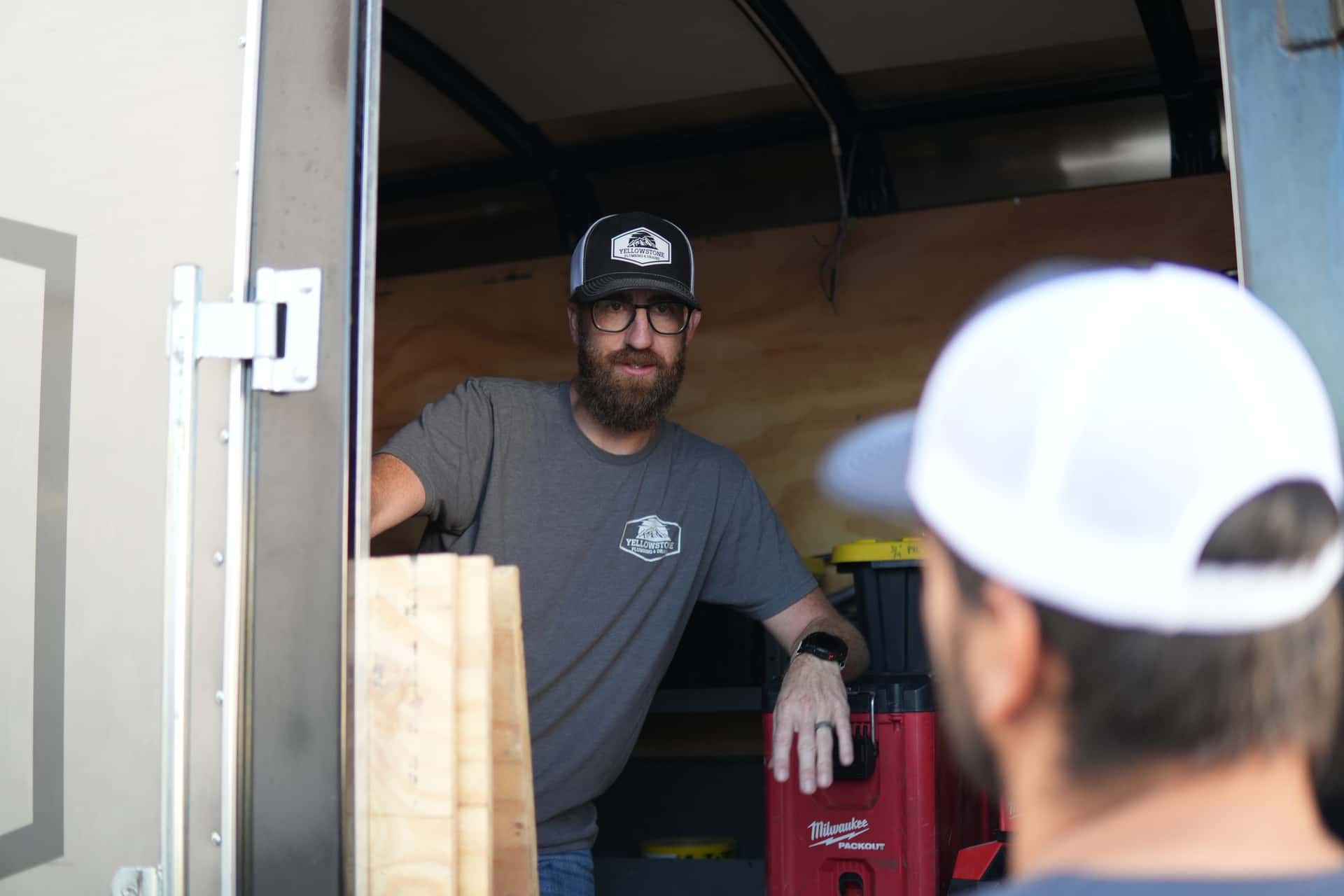 Yellowstone Plumbing technician beside the service trailer
