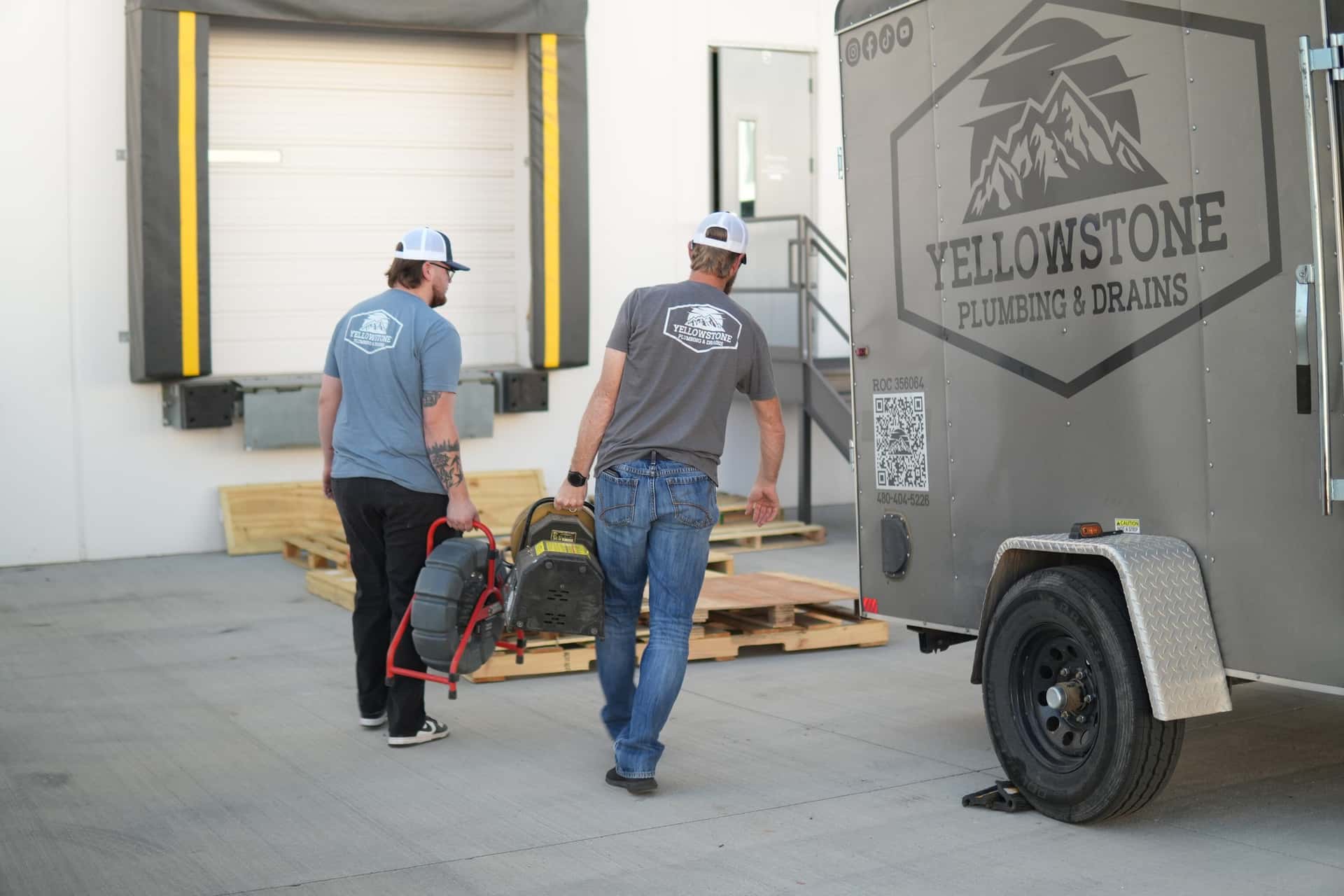 Two Yellowstone technicians walking from the trailer to a job