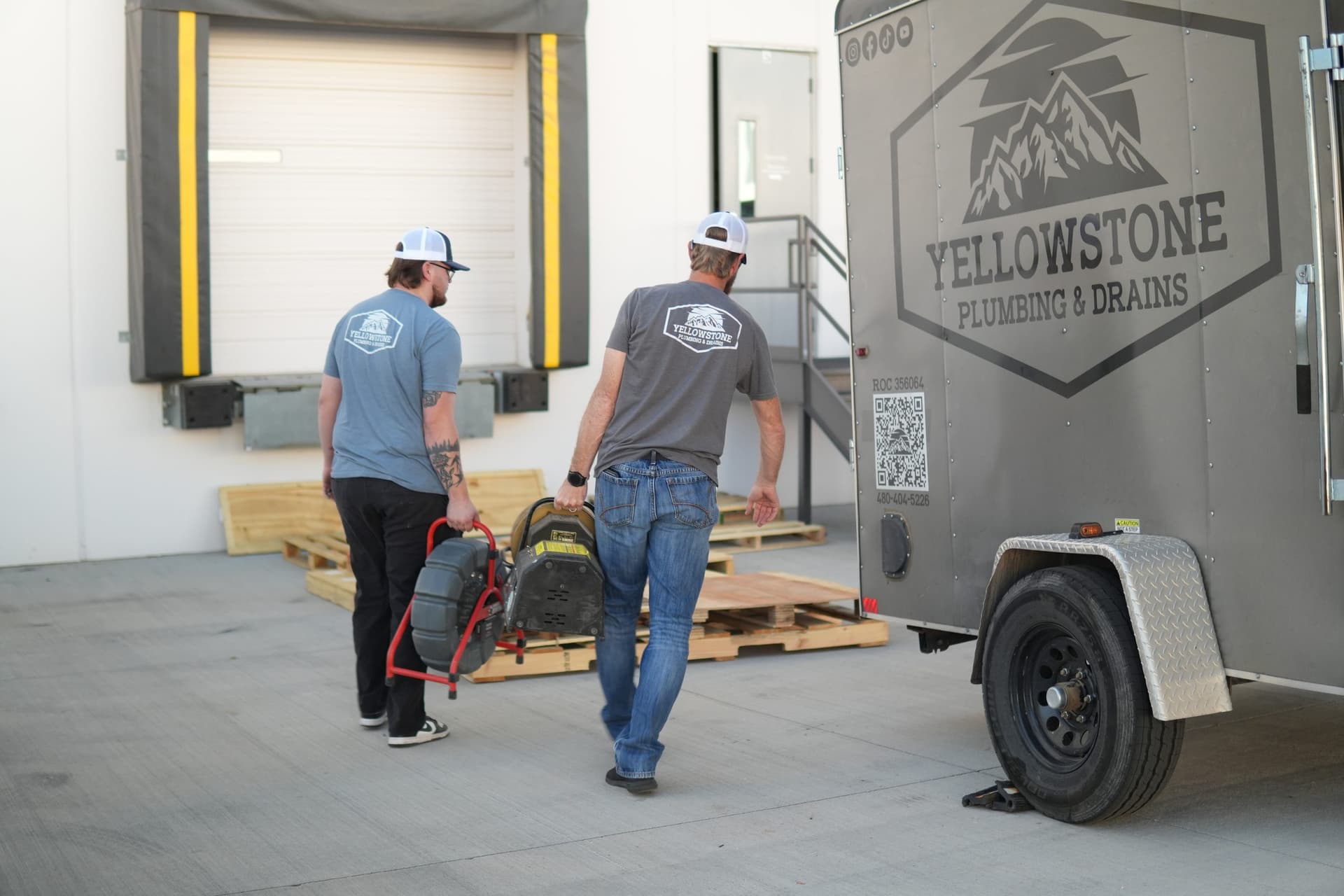 Two Yellowstone technicians walking from the trailer to a job