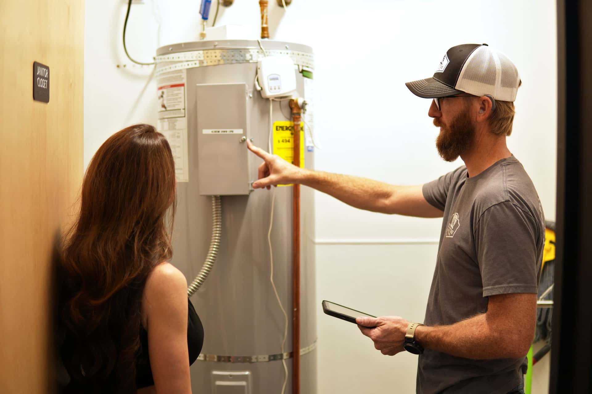 Yellowstone plumber explaining a water heater to a homeowner